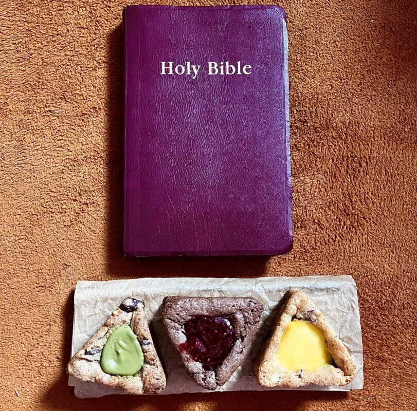 trinity cookies on a wooden plate, brown Bible above them